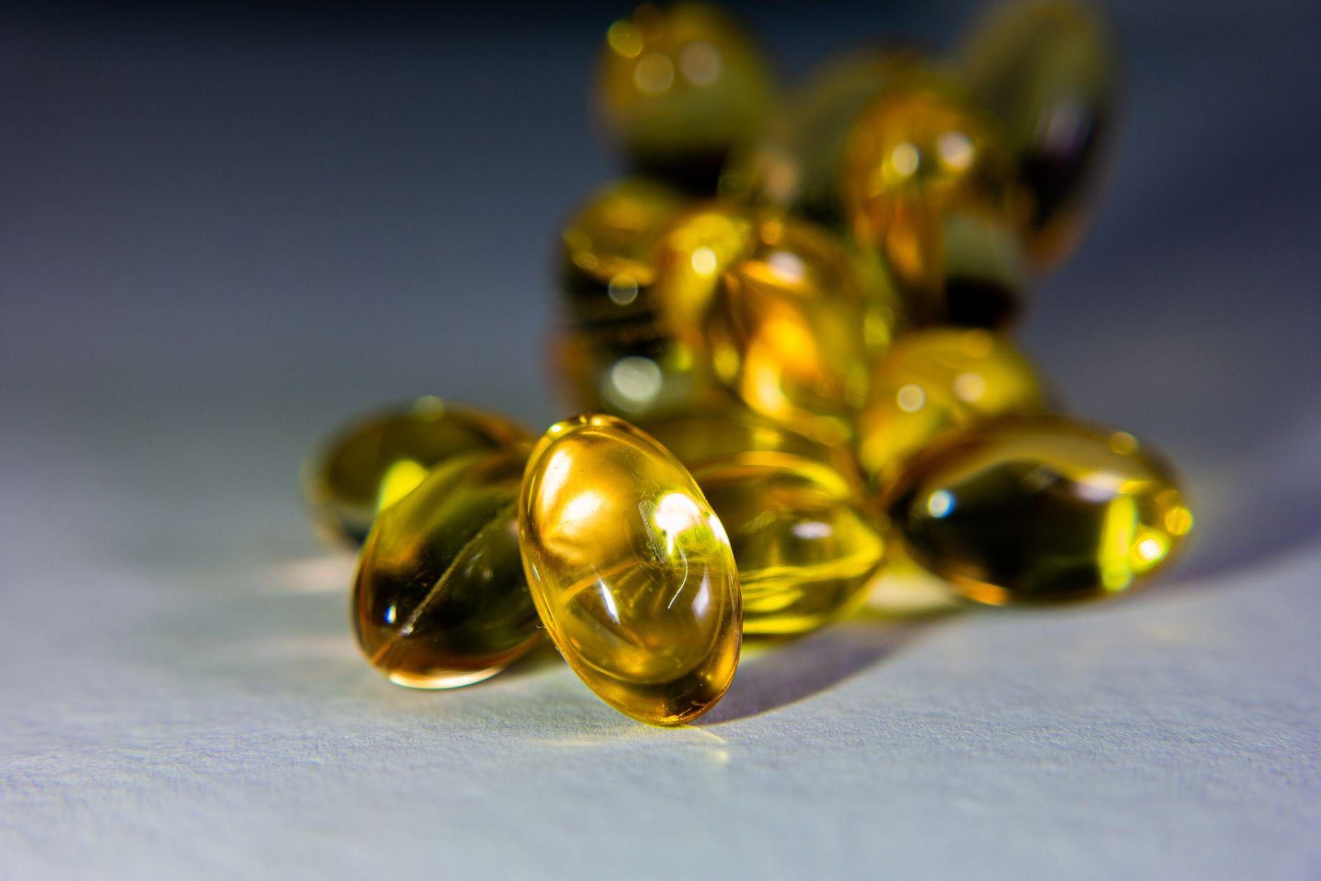 A close-up of vitamin E capsules spilling onto a table, representing nutritional support for stroke prevention.