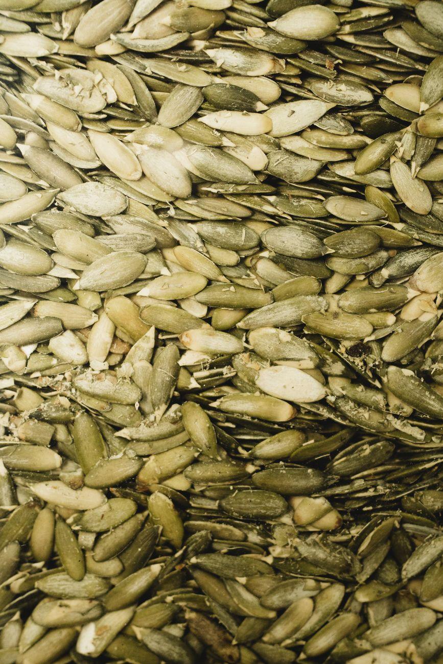 A variety of magnesium-rich foods like leafy greens, nuts, and seeds arranged on a wooden table.