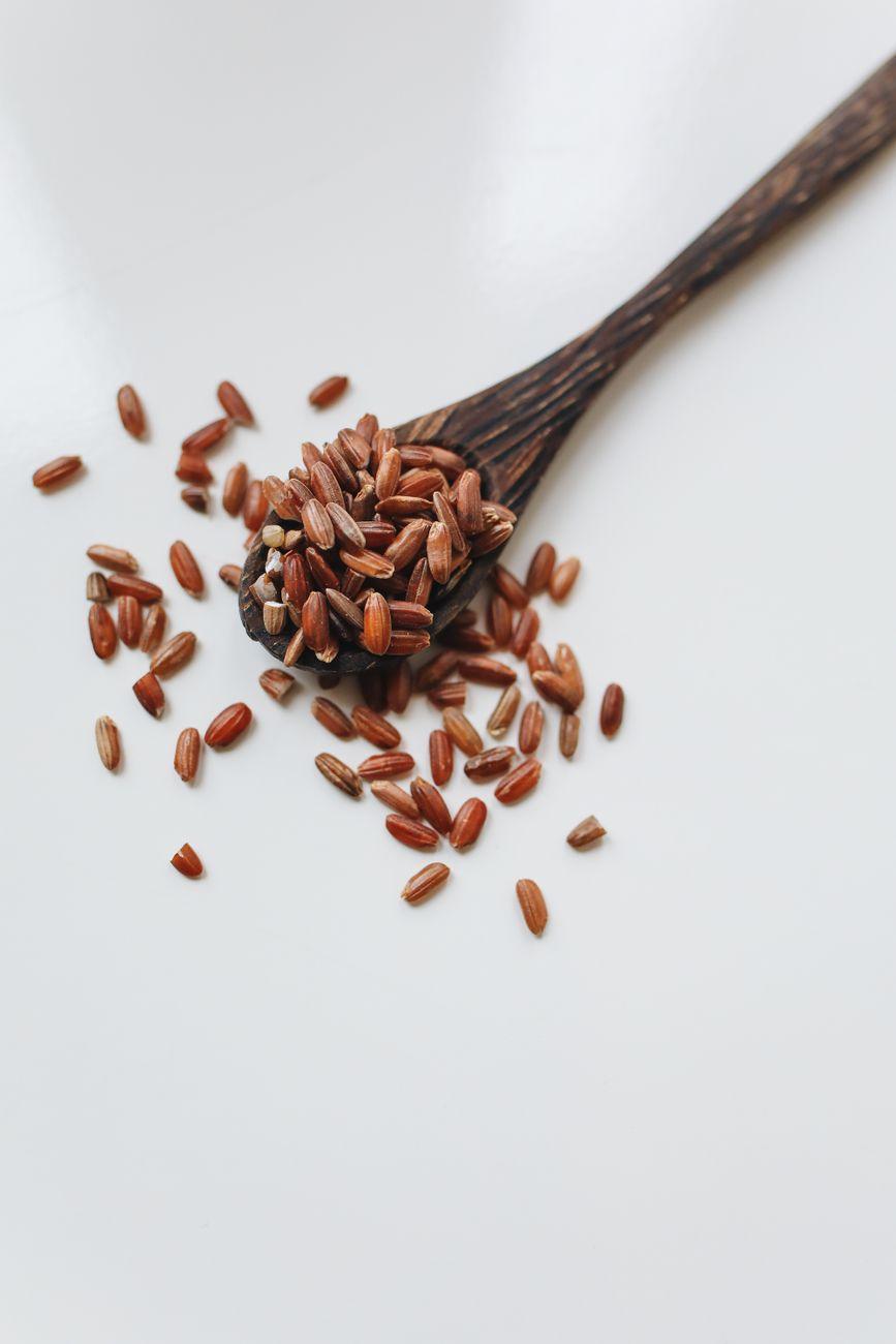 A bottle of red yeast rice capsules sitting on a wooden table next to a medical stethoscope.