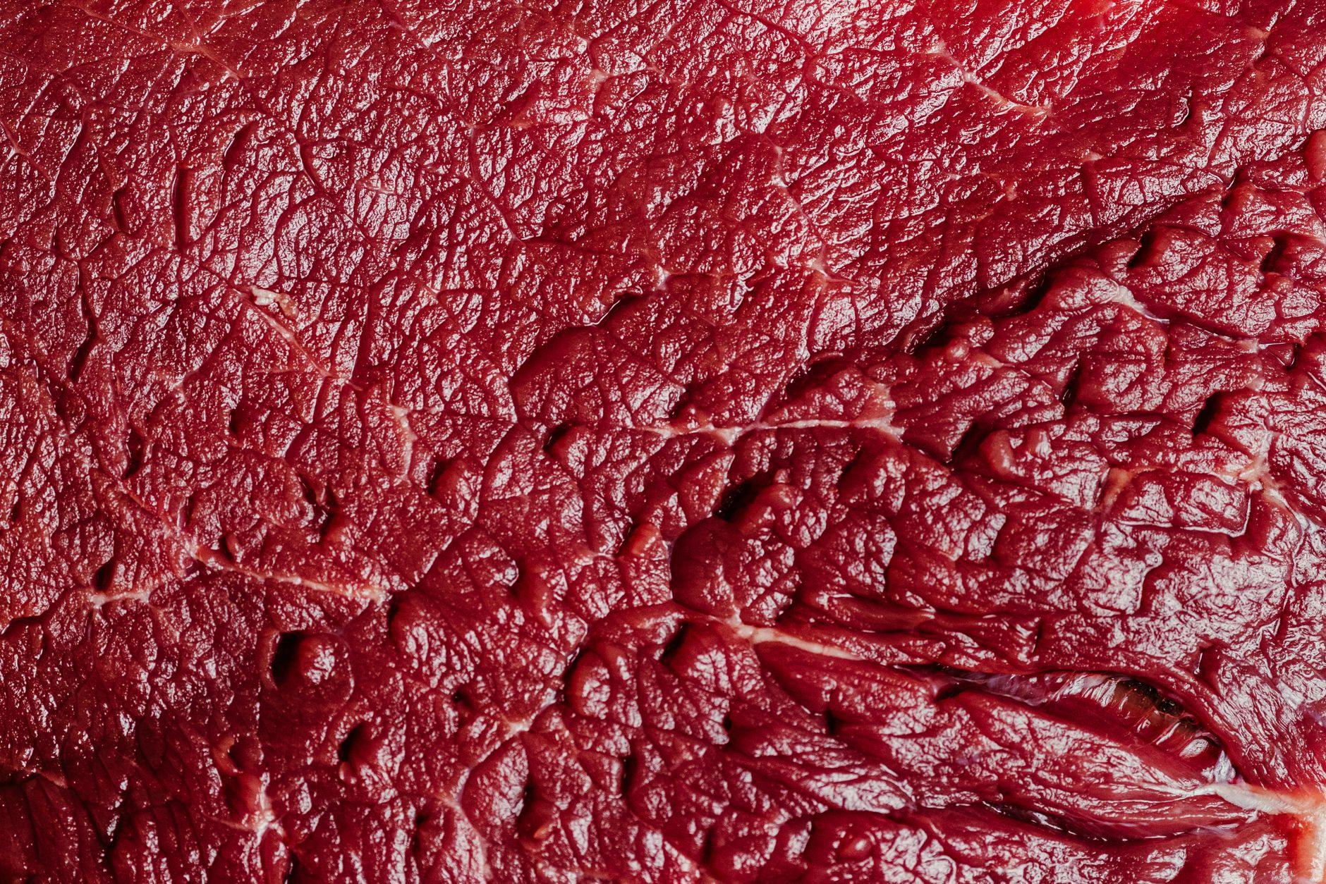 A close-up illustration showing a cross-section of an artery with red meat and heart health warning signs.